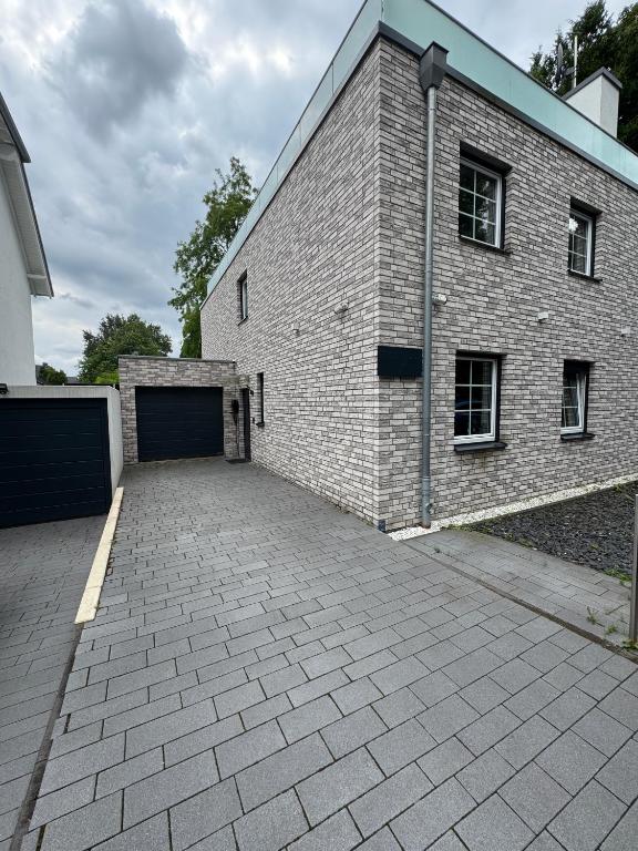 Un edificio de ladrillo con un estacionamiento al lado de un garaje. en Haus mit Parkplatz am Schloss Horst E02, en Essen