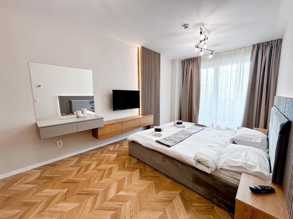 a bedroom with a large bed and a television at Airport Nest Private Parking, AC and Smart TV in Cluj-Napoca