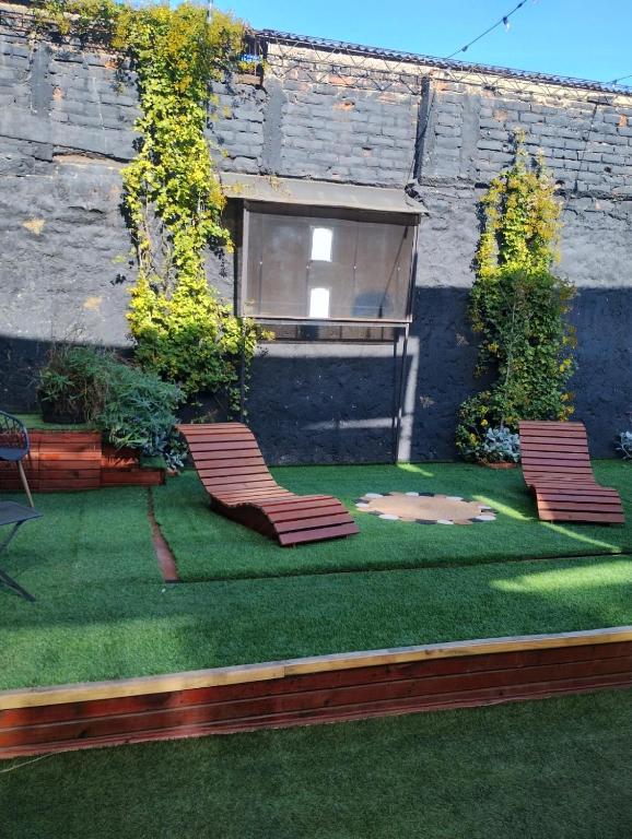 two chairs sitting on a lawn in front of a building at Beehouse Casa Miel Villa Alemana in Villa Alemana