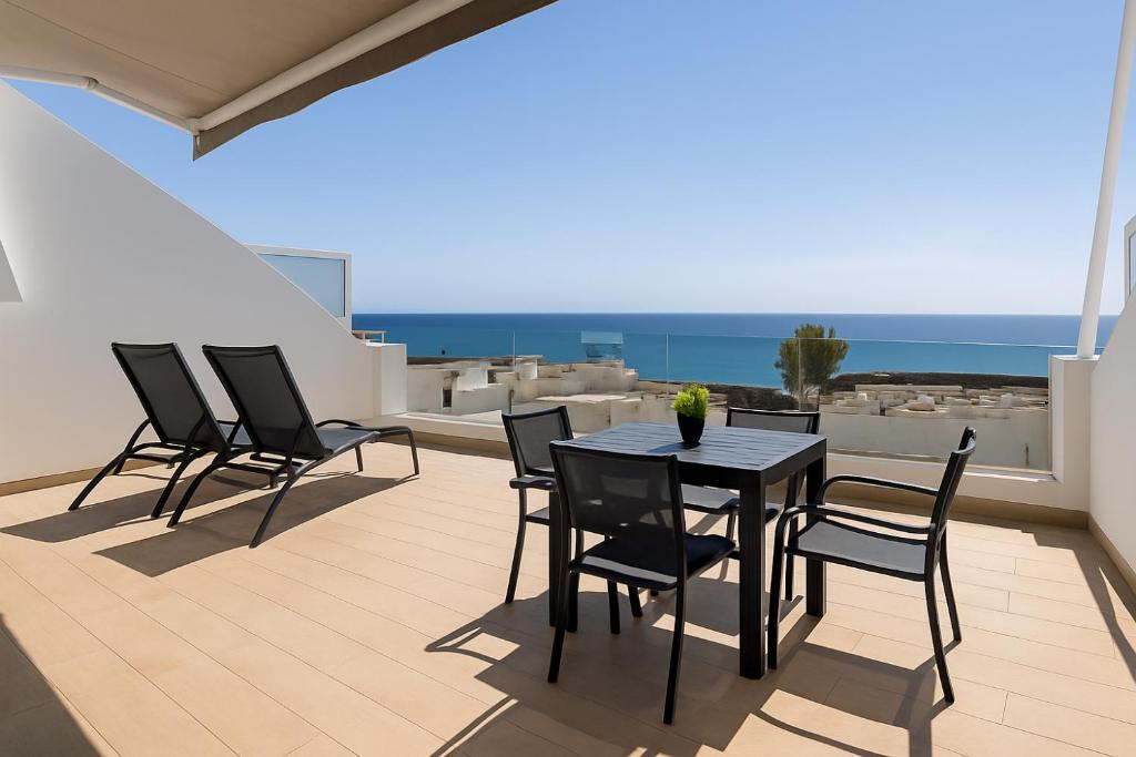 een terras met een tafel en stoelen op een balkon bij Arthouse Sea View - Acquamarina e Zaffiro in Puerto del Carmen