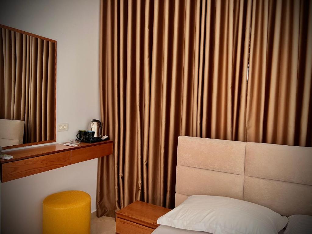 a hotel room with a bed and a window with curtains at Dine Hotel in Ksamil