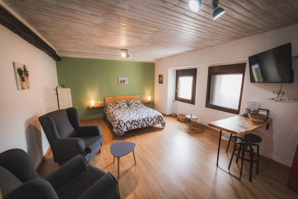 a bedroom with a bed and a couch and a table at O Noso Recuncho in Palas de Rei 