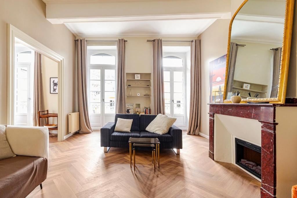 un salon avec un canapé et une cheminée dans l'établissement Magnifique appartement rénové, à Bagnères-de-Bigorre
