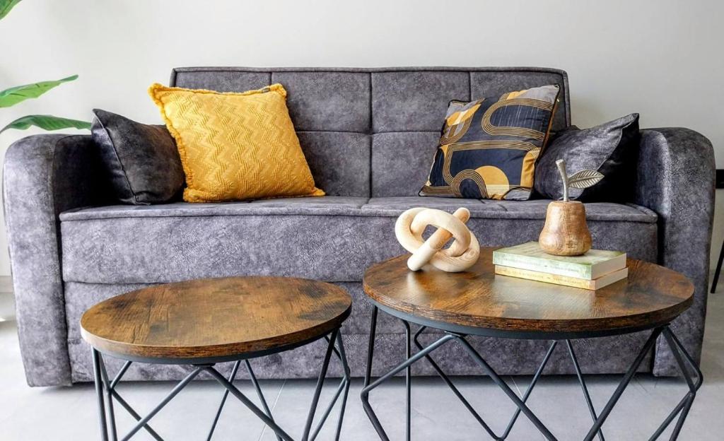 Una sala de estar con un sofá y dos mesas. en Ika Apartment Central, en Burgas