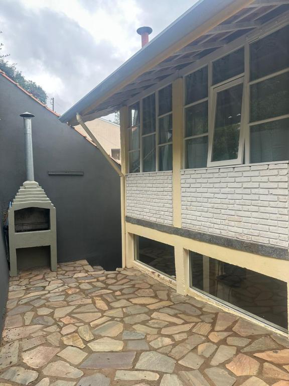 a house with a stone patio next to a building at Casa Quina da mata in Santo Antônio do Pinhal