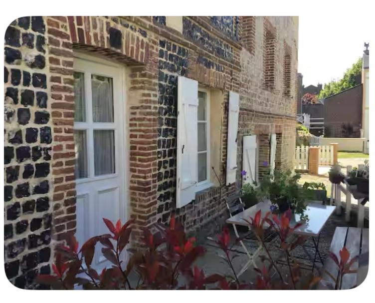 a brick building with a white door and windows at Charmante maison de pêcheur Etretat in Étretat