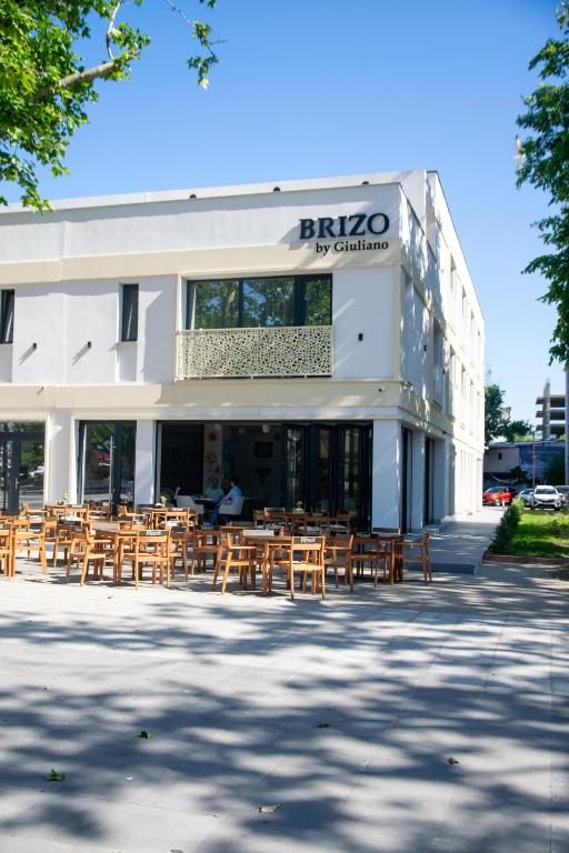 a building with tables and chairs in front of it at Brizo Boutique Hotel in Mamaia