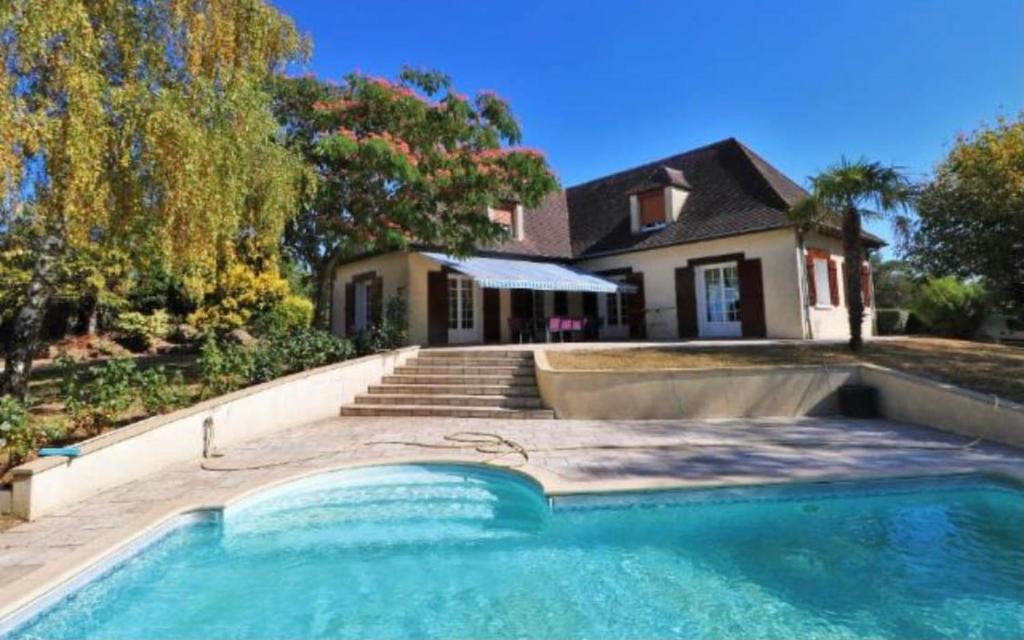 ein Haus mit einem Swimmingpool vor einem Haus in der Unterkunft Villa Relax avec Piscine Privée à 90 min de Paris in Saint-Hilaire-les-Andrésis