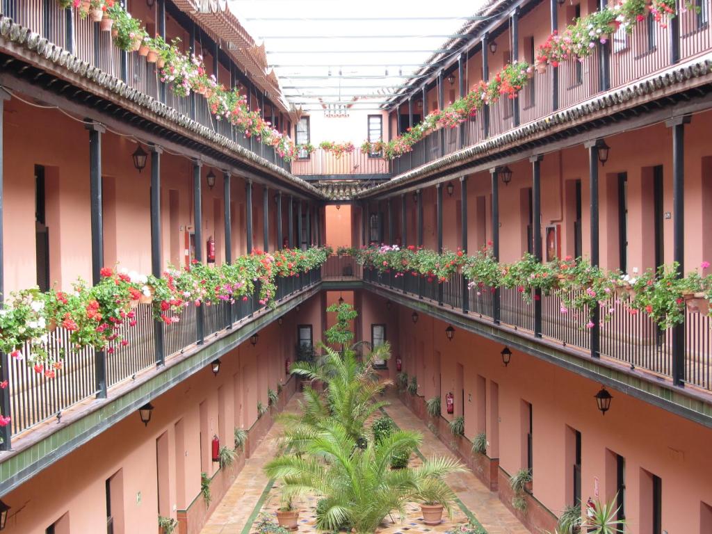 un patio interior de un edificio de apartamentos con plantas en los balcones en Un Viaje al Pasado en el Centro, en Sevilla