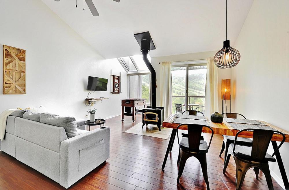 una sala de estar con un sofá y una mesa en 54 chemin de la Perdrix, en Stoneham