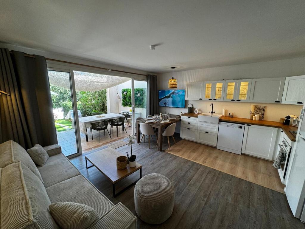 una cucina e un soggiorno con un divano e un tavolo di Villa Leona 3 Chambres et parc aquatique - Les Restanques a Grimaud