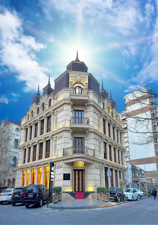 Un gran edificio blanco con coches aparcados delante. en Istanbul Gold Hotel, en Baku