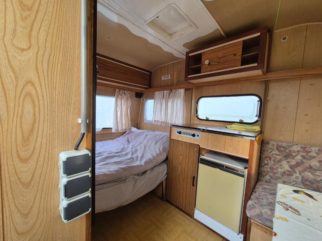 a small room with a bed and a kitchen in an rv at Atpūtas vieta Sīvera Medniekkrasti 