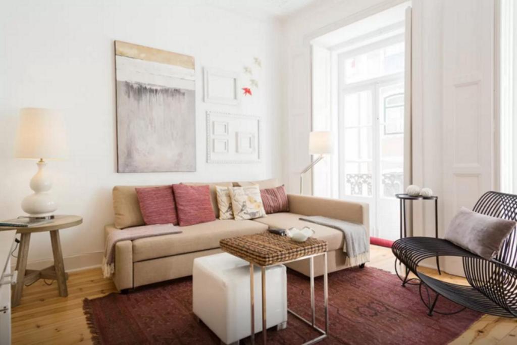 uma sala de estar com um sofá e uma mesa em Glória Apartment em Lisboa