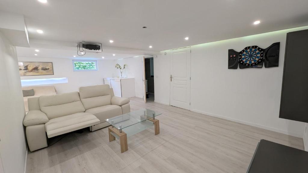 un salon avec un canapé et une table en verre dans l'établissement Les Loges de la Gallée, à Millery