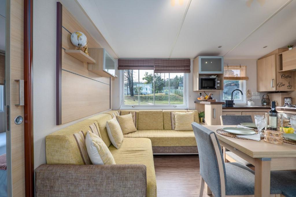 a living room and kitchen with a couch and a table at Glamping Frog Farm in Foz do Sousa
