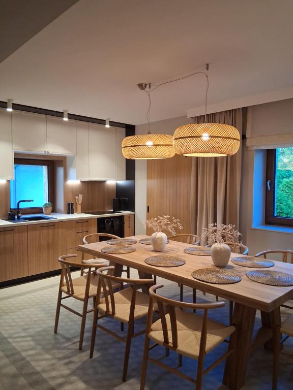 a dining room and kitchen with a table and chairs at Sileo Nature in Ustka