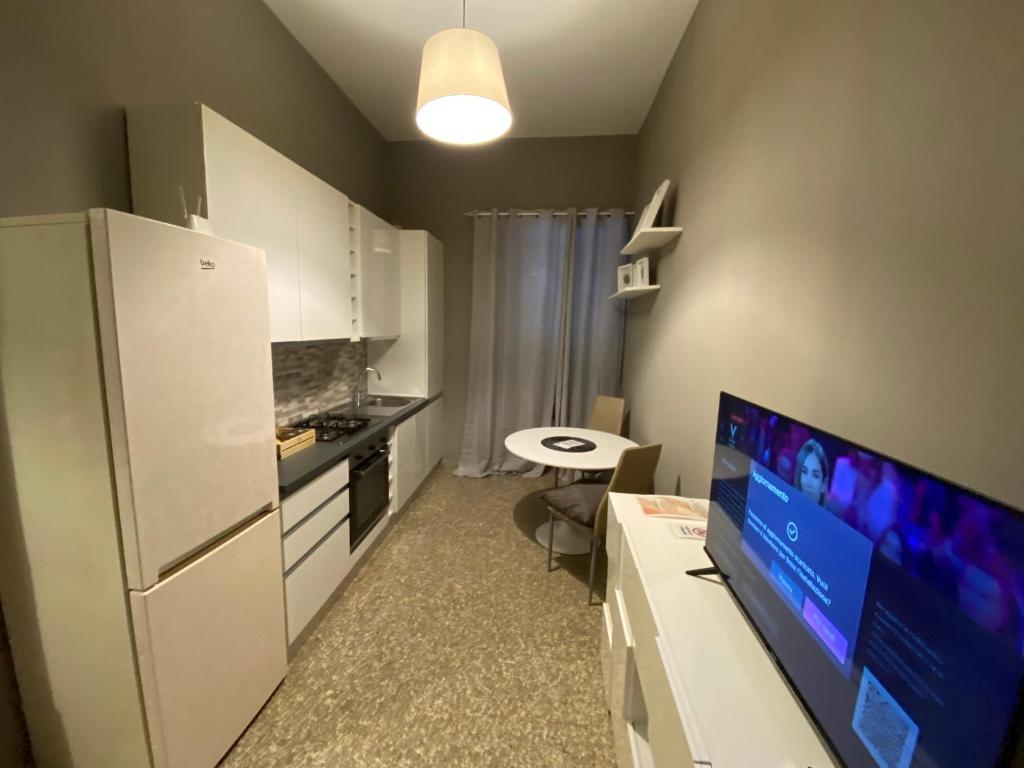 a small kitchen with a white refrigerator and a table at Il Nido del Falco Apartment in Castel Gandolfo
