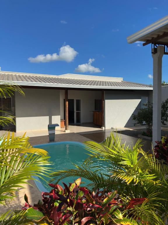 a swimming pool in front of a house at Casa 2min do Centro c Piscina in Bonito