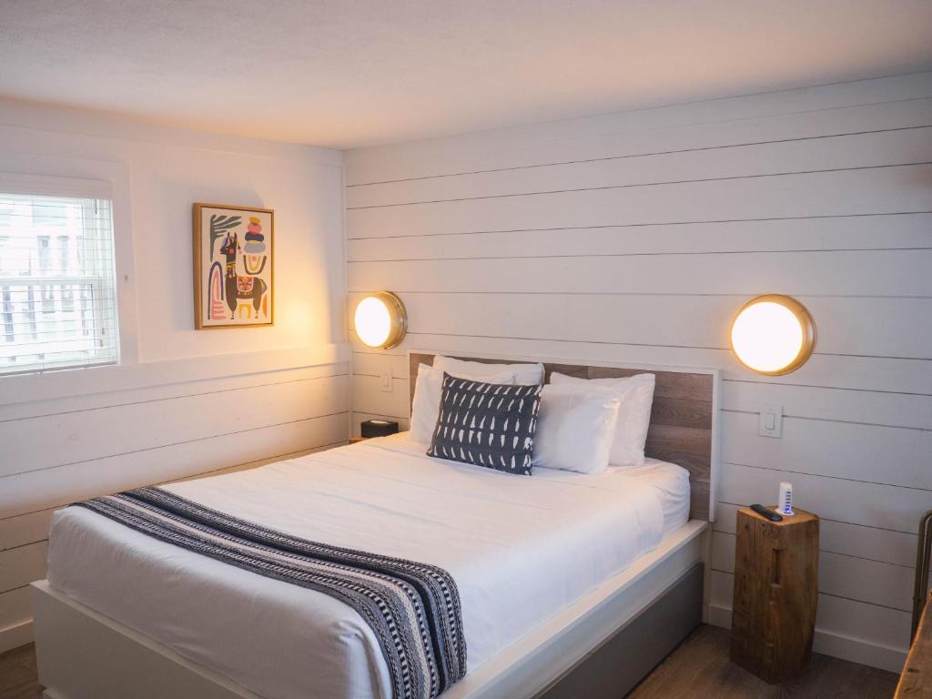 a bedroom with a bed with two lights on it at Stones Throw in York Beach
