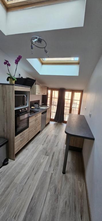 une grande cuisine avec une table au milieu dans l'établissement L'appart des vignes, à Nuits-Saint-Georges