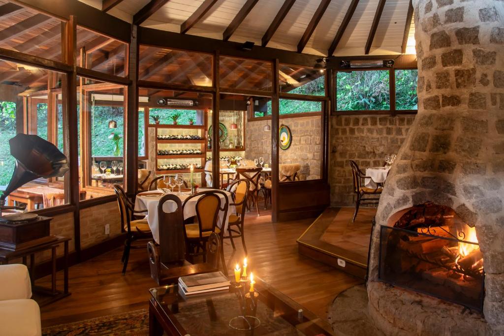 a fireplace in a restaurant with a table and chairs at Pousada Tijupá in Visconde De Maua