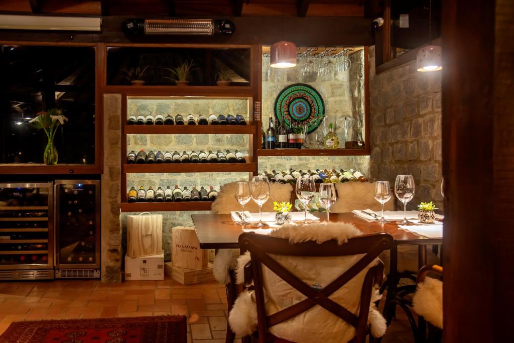 a dining room with a table with wine glasses at Pousada Tijupá in Visconde De Maua