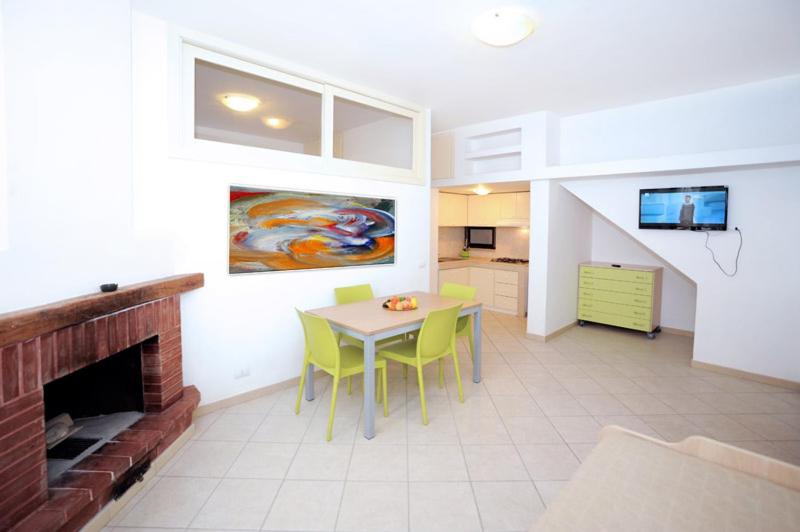 ein Wohnzimmer mit einem Tisch und einem Kamin in der Unterkunft Appartamenti Castello in Peschici