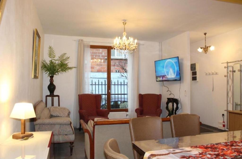 - un salon avec un lustre, une table et des chaises dans l'établissement Maison de charme 86m2 à Saint-Denis Pleyel, 4 chambres, terrasse, calme, proche Paris et Stade de France, à Saint-Denis