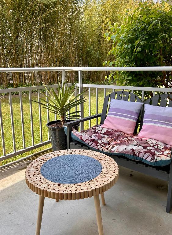 d'une table et d'un banc installés sur une terrasse. dans l'établissement Le cosy bisca-Parking-terasse-Lac-Océan, à Biscarrosse