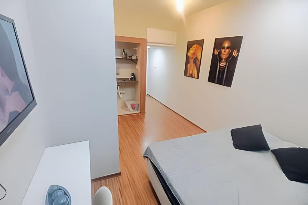 een slaapkamer met een bed en een tv aan de muur bij Studio 1103 - Centro Niterói in Niterói