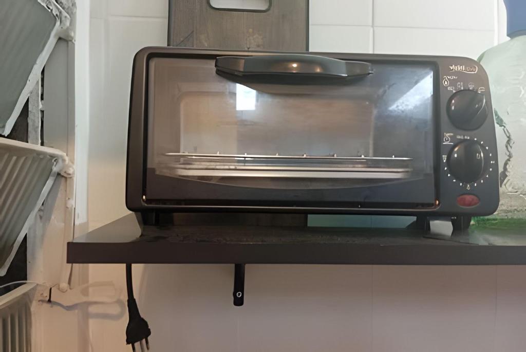a toaster oven sitting on a shelf in a kitchen at Studio 1103 - Centro Niterói in Niterói