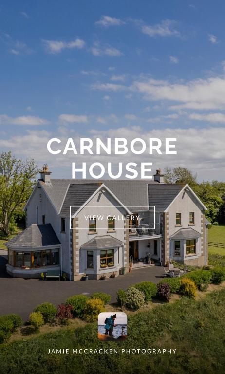 a large white house with the words caralore house at Carnbore House BnB in Bushmills