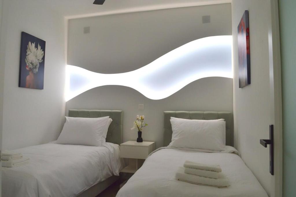 Un dormitorio con dos camas y una ventana. en Helen Apartment, en Ermoupoli