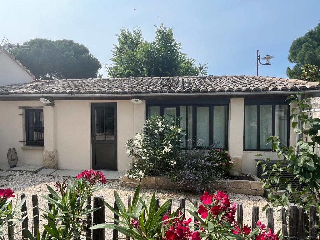 une maison blanche avec une clôture et des fleurs dans l'établissement Vacances face au Luberon, à Robion
