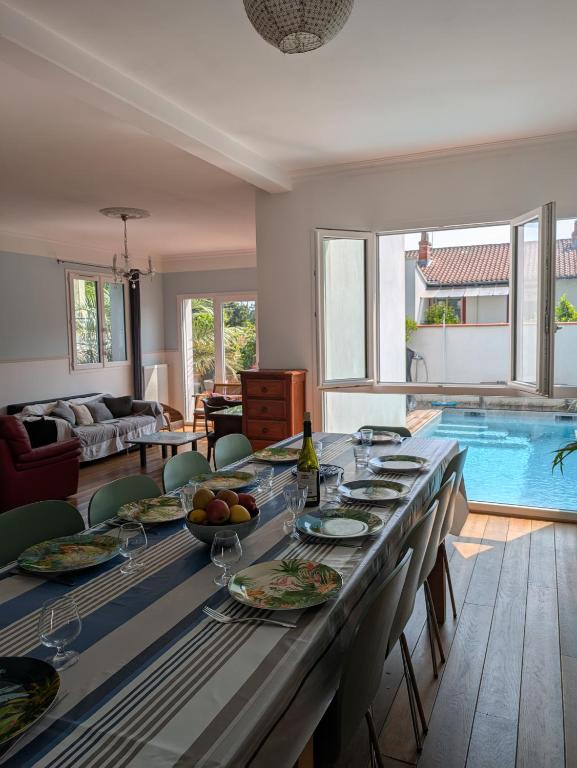 une salle à manger avec une table et une piscine dans l'établissement Belle maison, beau quartier, piscine, proche centre, 5 chambres, à Toulouse