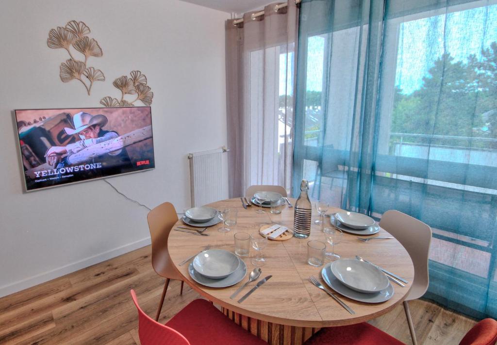 une salle à manger avec une table en bois et une télévision dans l'établissement Suite T6 Rennes - Idéal Entreprises & Familles, à Rennes