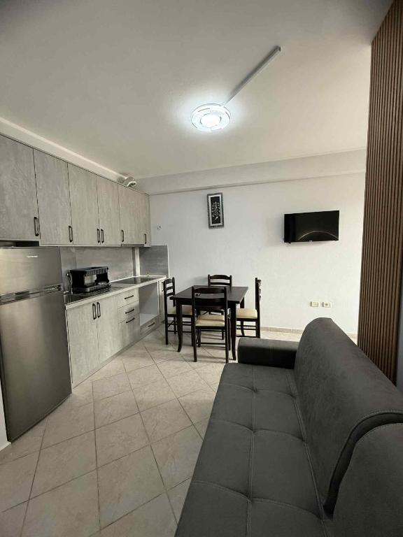 a kitchen with a couch and a table in a room at Shëngjin Beach Nest in Lezhë