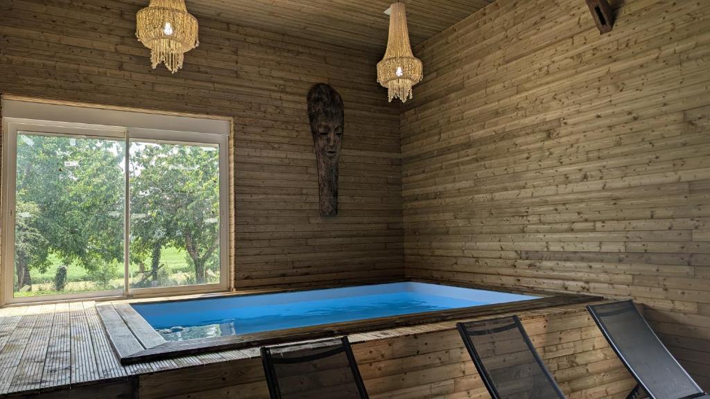 - une piscine dans une pièce dotée d'un mur en briques dans l'établissement Gîte des champs étoilés, à Thuboeuf