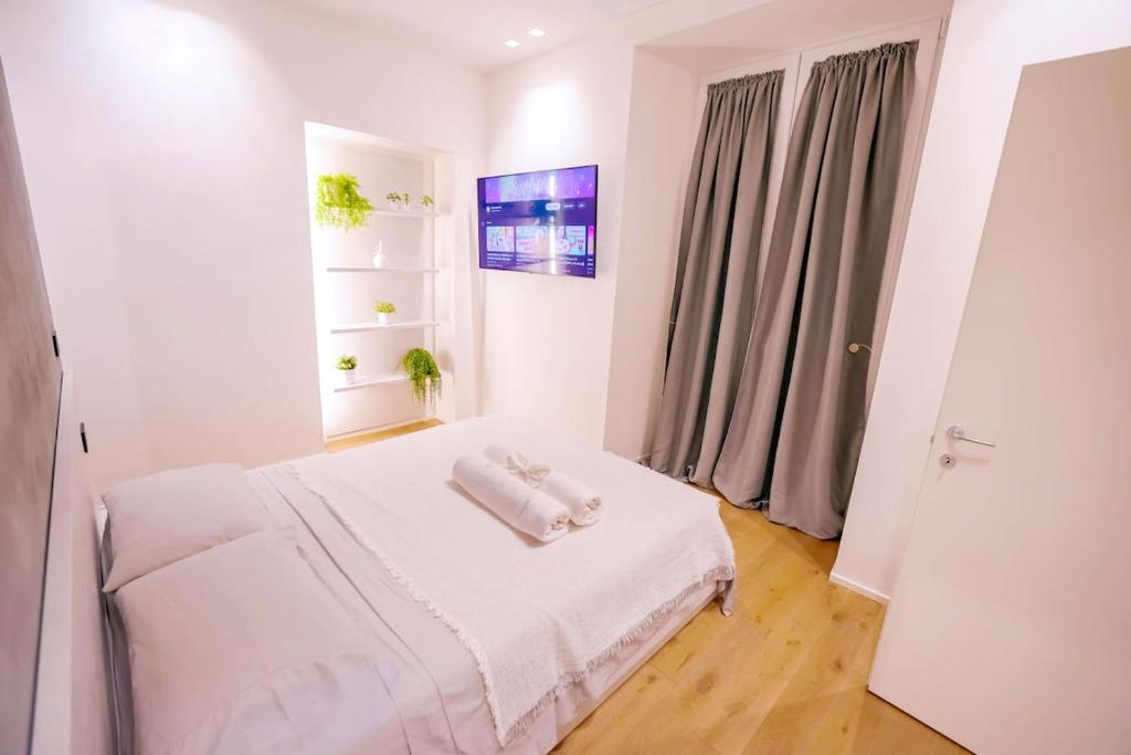 a white room with a bed with towels on it at Central-Luxury Free Wi-Fi, AC in Genova