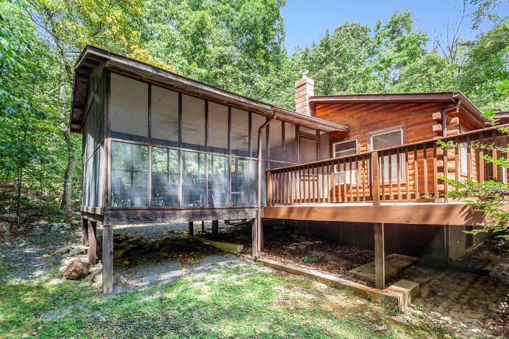 a cabin in the woods with a large deck at Private w Screened Porch, Deck & Dog-Friendly! in Luray