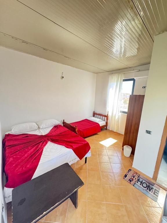 a bedroom with two beds with red sheets at Morina Rooms in Durrës