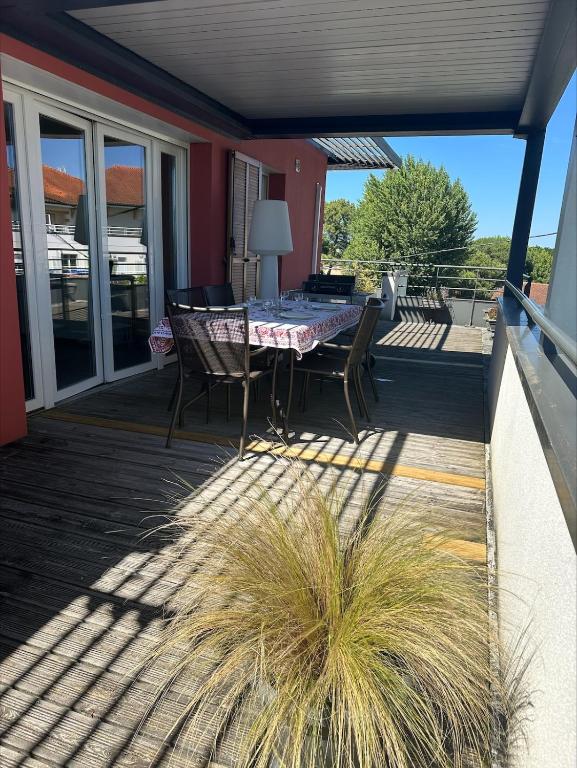 un patio avec une table et des chaises sur une terrasse dans l'établissement Toit terrasse à Andernos les Bains, à Andernos-les-Bains