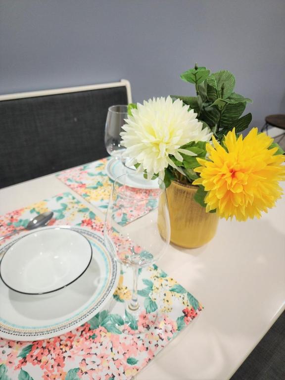 a table with a plate and a vase of flowers at Gorgeous Two Bedroom Suite in a Quiet, Picturesque Neighborhood! in West Vancouver