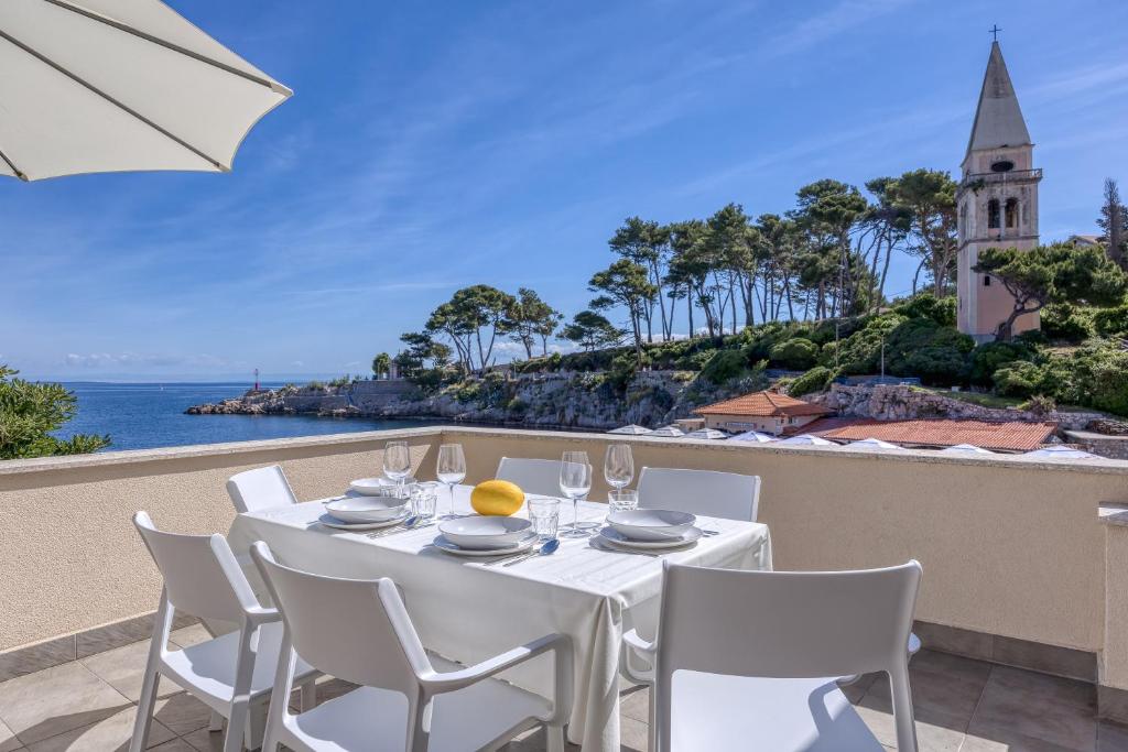 a table with white chairs and a view of the ocean at Panorama Apartment Veli Lošinj - Happy Rentals in Veli Lošinj