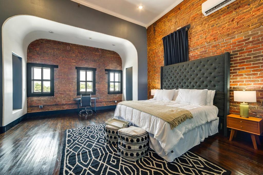 una camera da letto con un letto grande e un muro di mattoni di Historic Downtown Location Marshall Studio Escape a Marshall