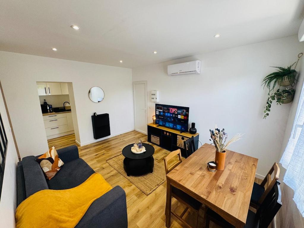 - un salon avec un canapé bleu et une table en bois dans l'établissement Le Moga - WIFI - TV, à Bègles