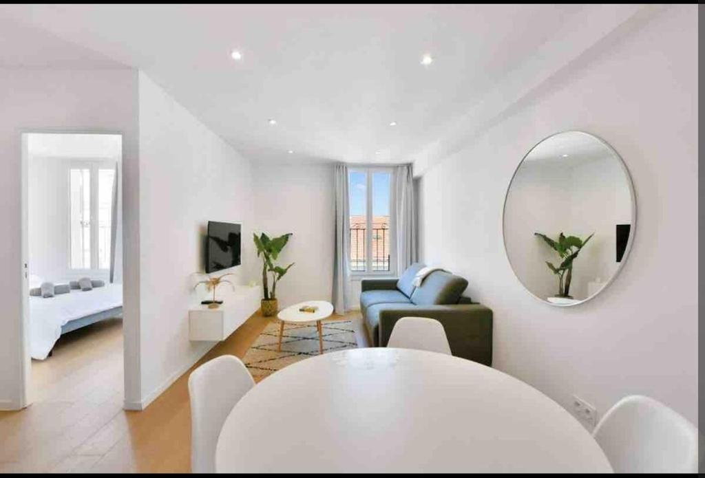 - un salon blanc avec une table et un miroir dans l'établissement Beautiful 2-room apartment on the Croisette in Cannes, à Cannes