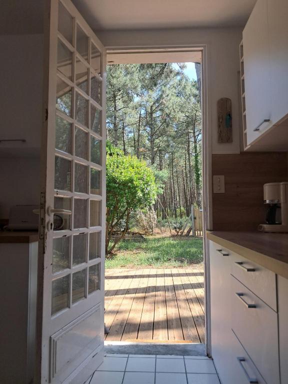 une cuisine avec une porte menant à une cour dans l'établissement Savannah - La maison des pins, à Mimizan-Plage