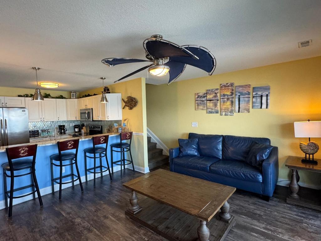 a living room with a blue couch and a kitchen at Put-in-Bay Waterfront Condo #209 in Put-in-Bay